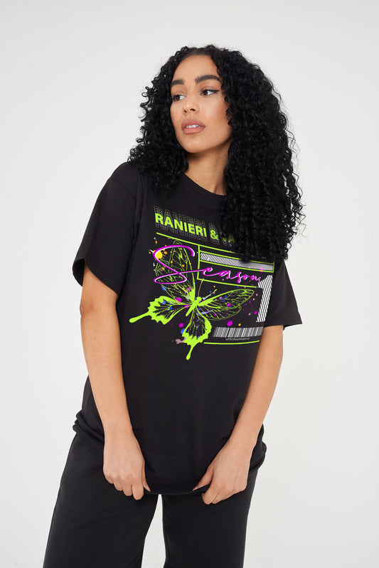 A woman wearing an oversized green Butterfly Season One graphic t-shirt with casual styling.