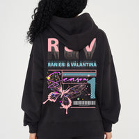 Woman wearing pink Butterfly Season One graphic hoodie styled casually, showing back print and relaxed fit.