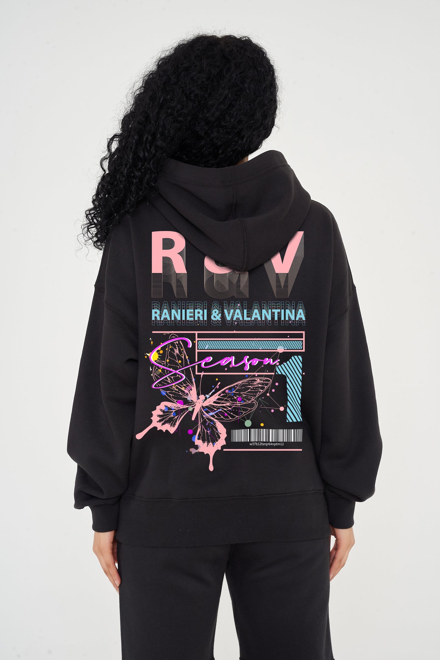 Woman wearing pink Butterfly Season One graphic hoodie styled casually, showing back print and relaxed fit.