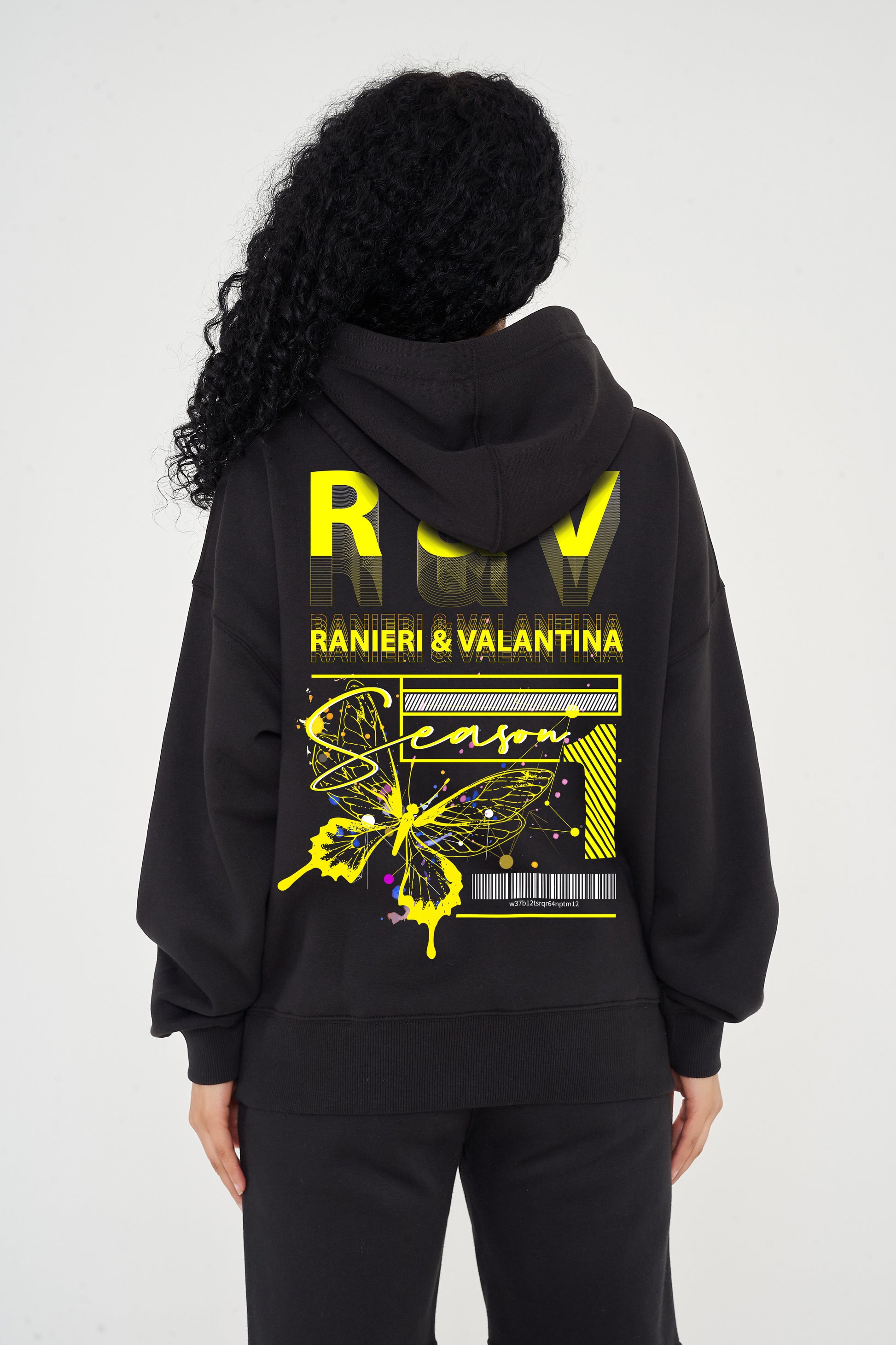Woman wearing yellow Butterfly Season One graphic hoodie styled casually, showing back print and relaxed fit.