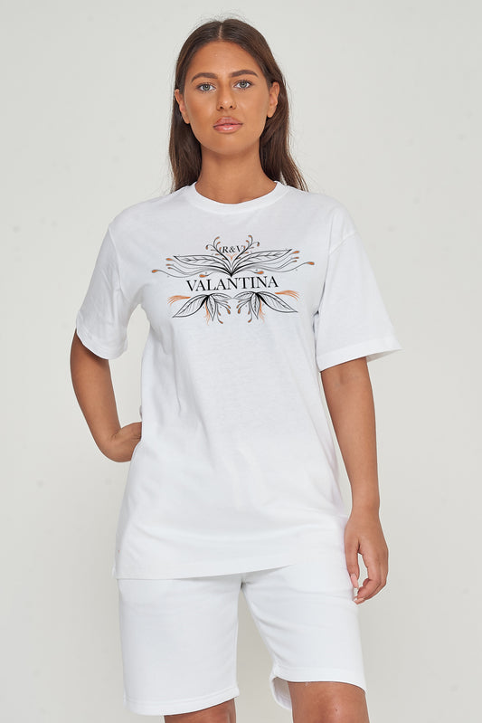 Woman wearing the white Copper Peacock Oversized T-Shirt styled with casual denim bottoms, highlighting the striking copper peacock print and comfortable fit.