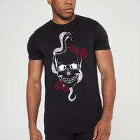 Male model front view wearing black Fatal T-shirt with skull and snake graphic, styled with black jeans - regular fit.