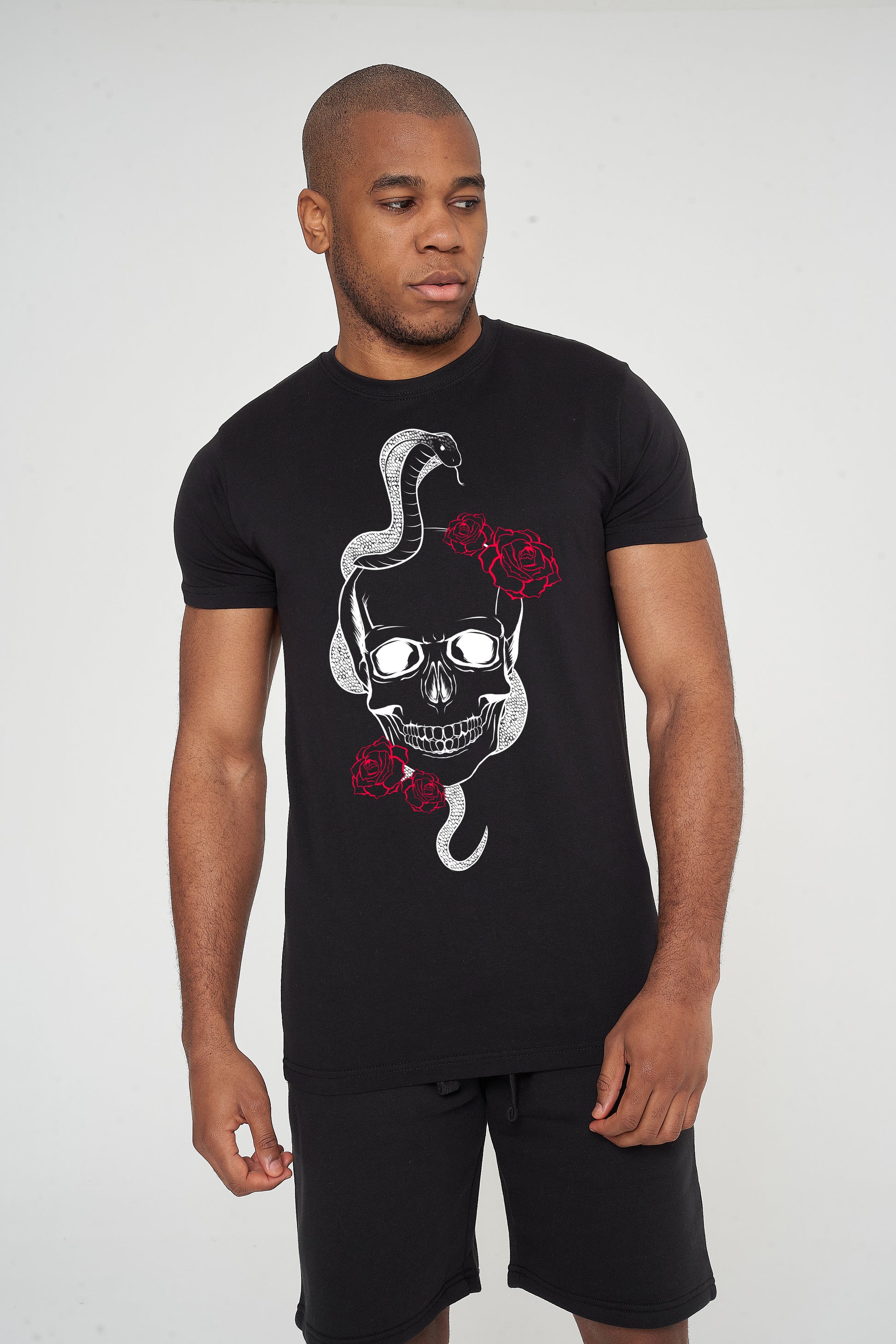 Male model front view wearing black Fatal T-shirt with skull and snake graphic, styled with black jeans - regular fit.