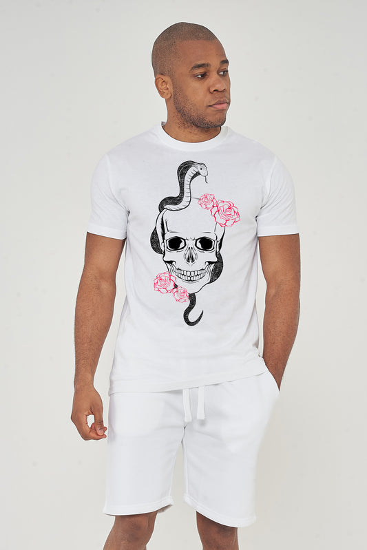 Male model front view wearing white Fatal T-shirt with skull and snake graphic, styled with white shorts – regular fit.