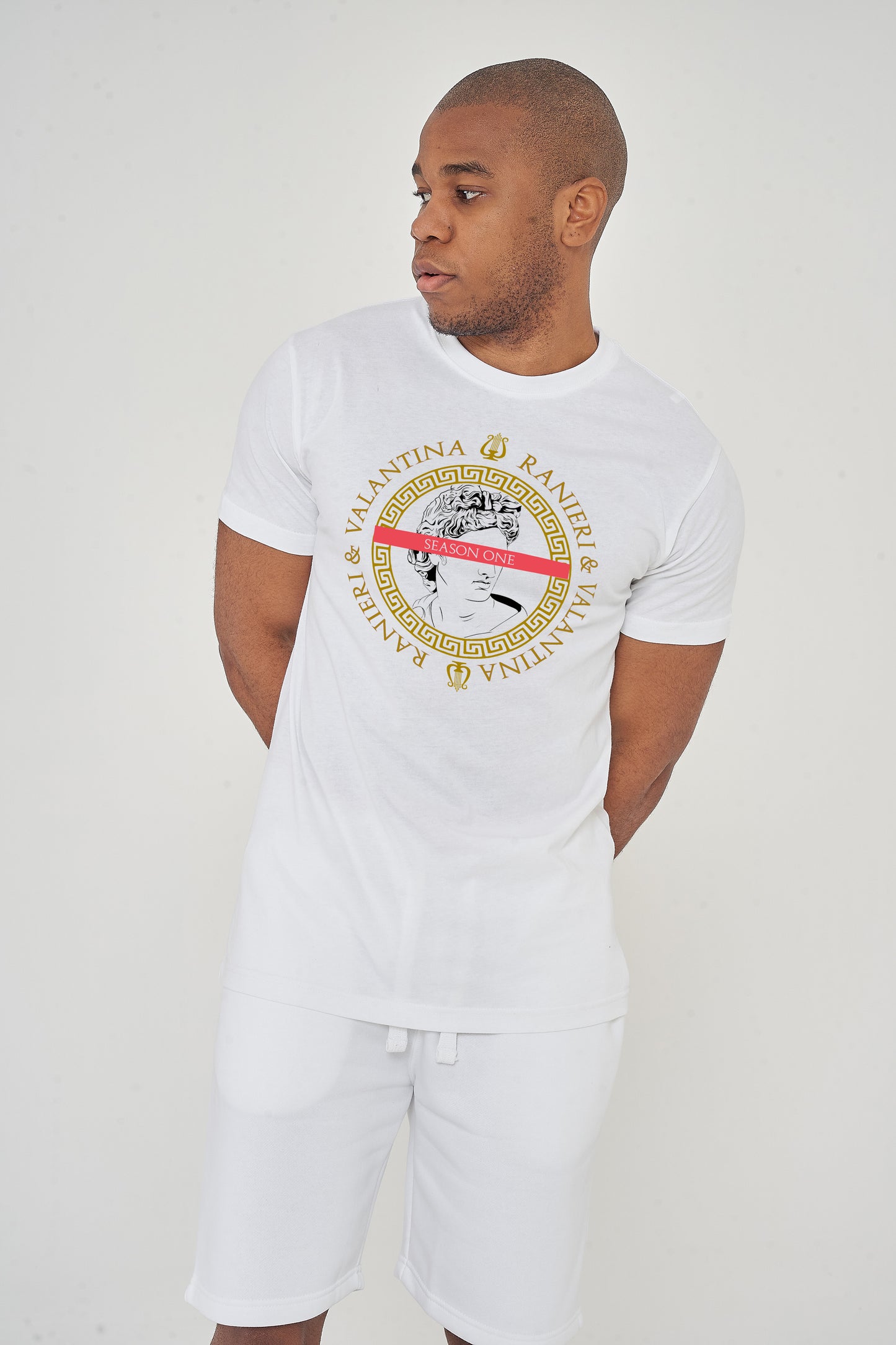 Man wearing the white Greece Season One T-Shirt styled with casual bottoms, highlighting the bold front graphic and comfortable oversized silhouette.