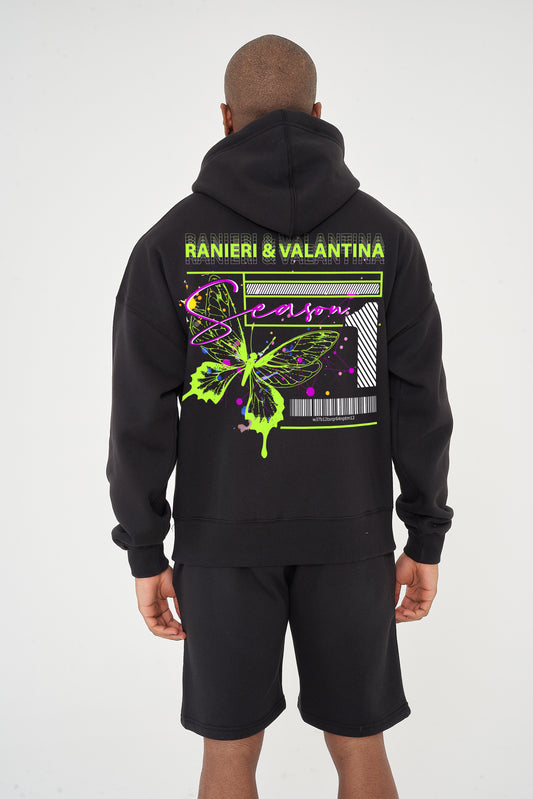 Rear view of male model wearing black oversized hoodie with vivid green butterfly graphic and Ranieri & Valantina logo – oversized fit.