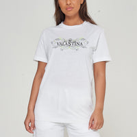 Woman wearing the white Green Peacock Oversized T-Shirt styled with casual bottoms, highlighting the front peacock print and comfortable fit.