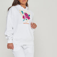 Woman wearing the white Gumamela Flower Oversized Hoodie styled with casual bottoms, highlighting the vibrant front floral print and comfortable oversized fit.