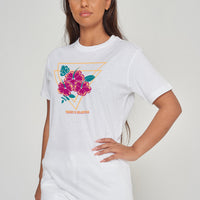 Woman wearing the white Gumamela Flower T-Shirt styled with casual bottoms, highlighting the bold front floral print and comfortable oversized fit.