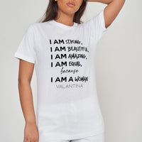 Woman wearing the white I AM A WOMAN Oversized T-Shirt styled with casual bottoms, highlighting the prominent empowering front print and comfortable oversized fit.
