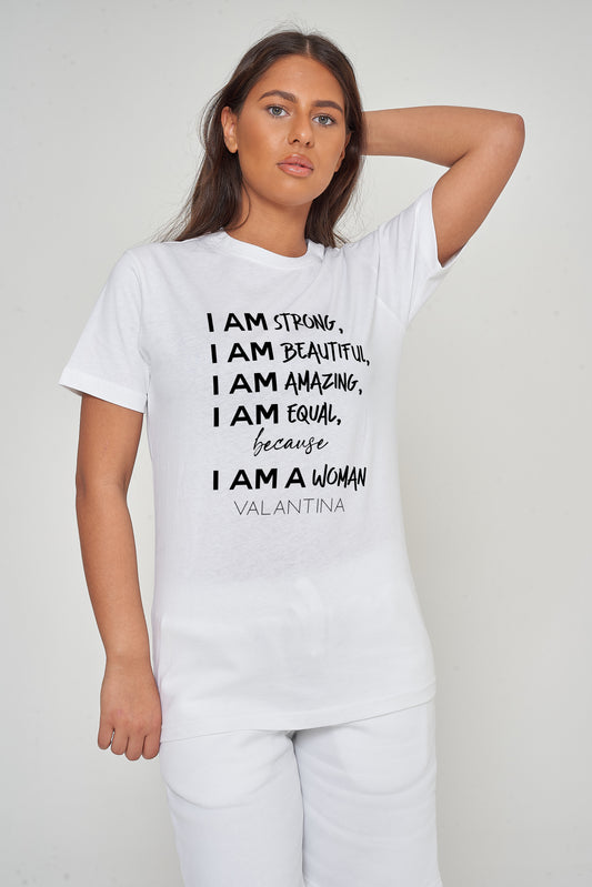 Woman wearing the white I AM A WOMAN Oversized T-Shirt styled with casual bottoms, highlighting the prominent empowering front print and comfortable oversized fit.