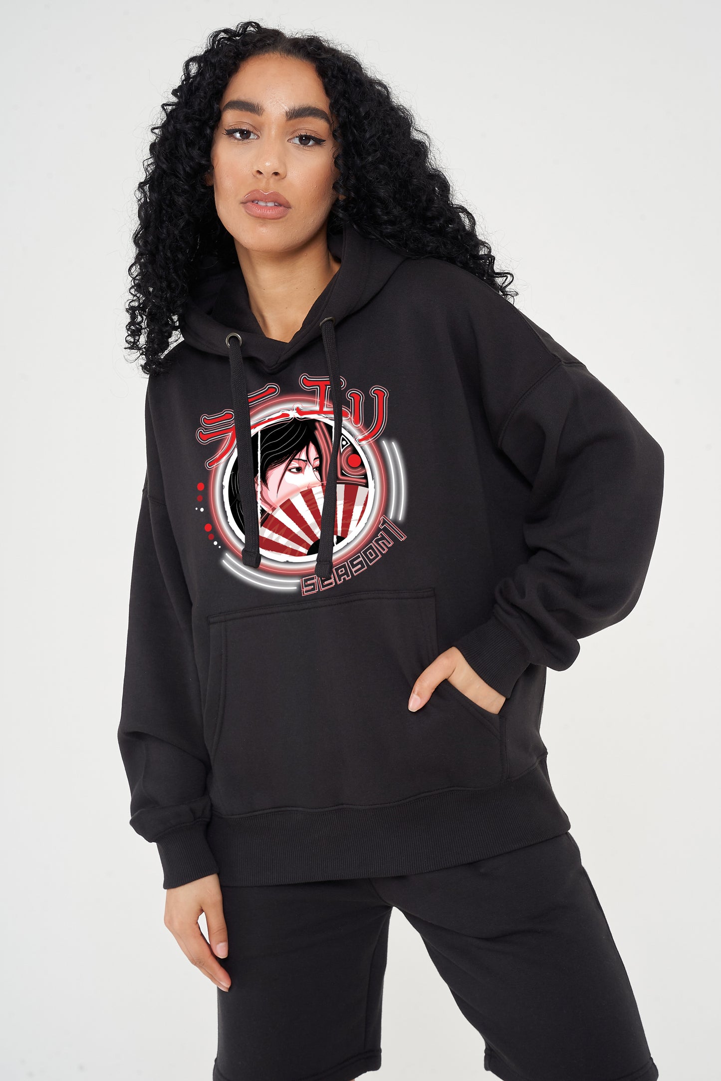 Woman wearing the Japanese Lady Season 1 Hoodie in black styled with casual bottoms, highlighting the front graphic, oversized fit, and hoodie details.