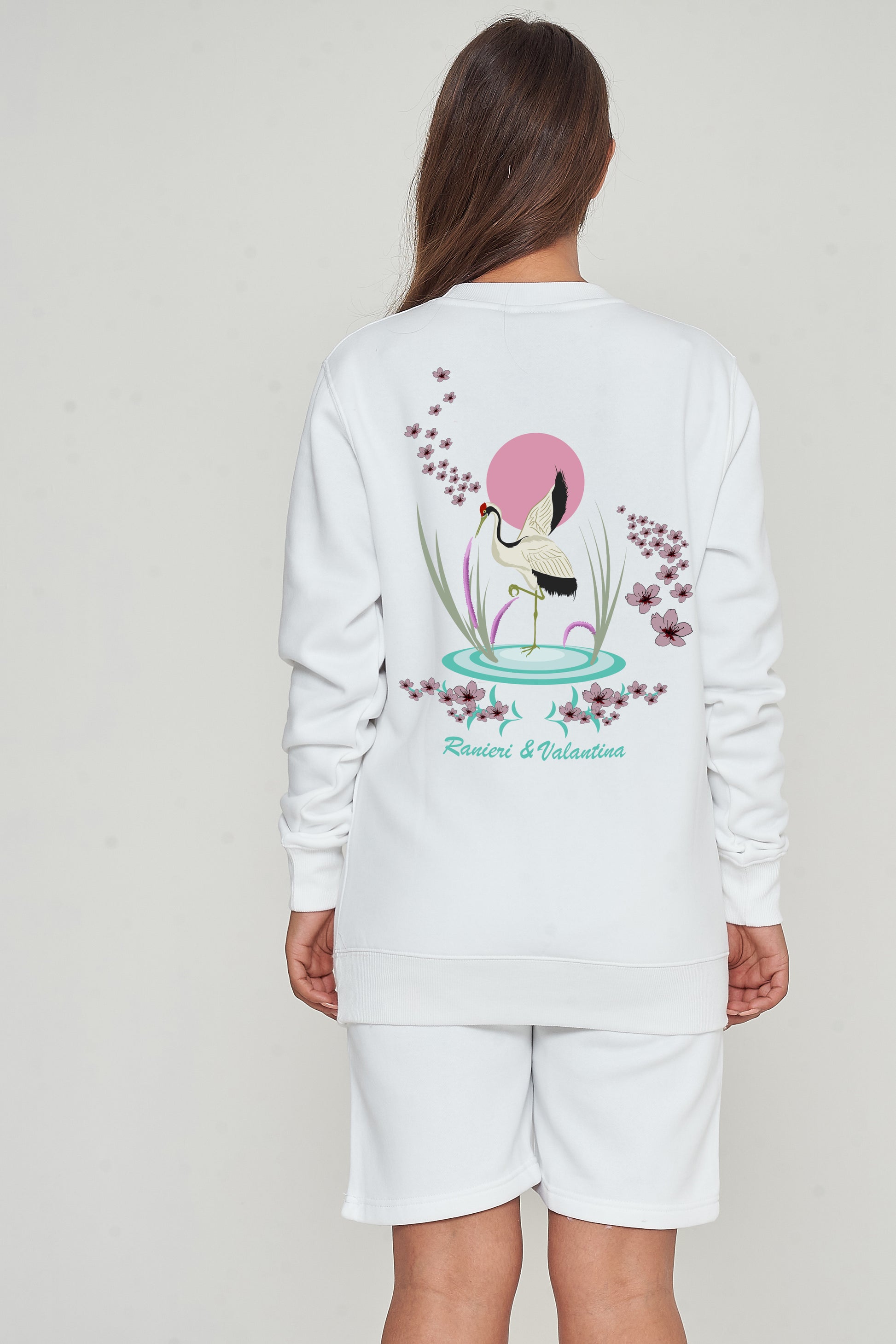 Woman wearing a white Japanese Waters sweatshirt, back view highlighting a unique Japanese-inspired print.