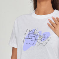 Woman wearing the Lilac Flower Art Oversized T-Shirt styled with casual bottoms, highlighting the gentle front flower print and comfortable oversized fit.