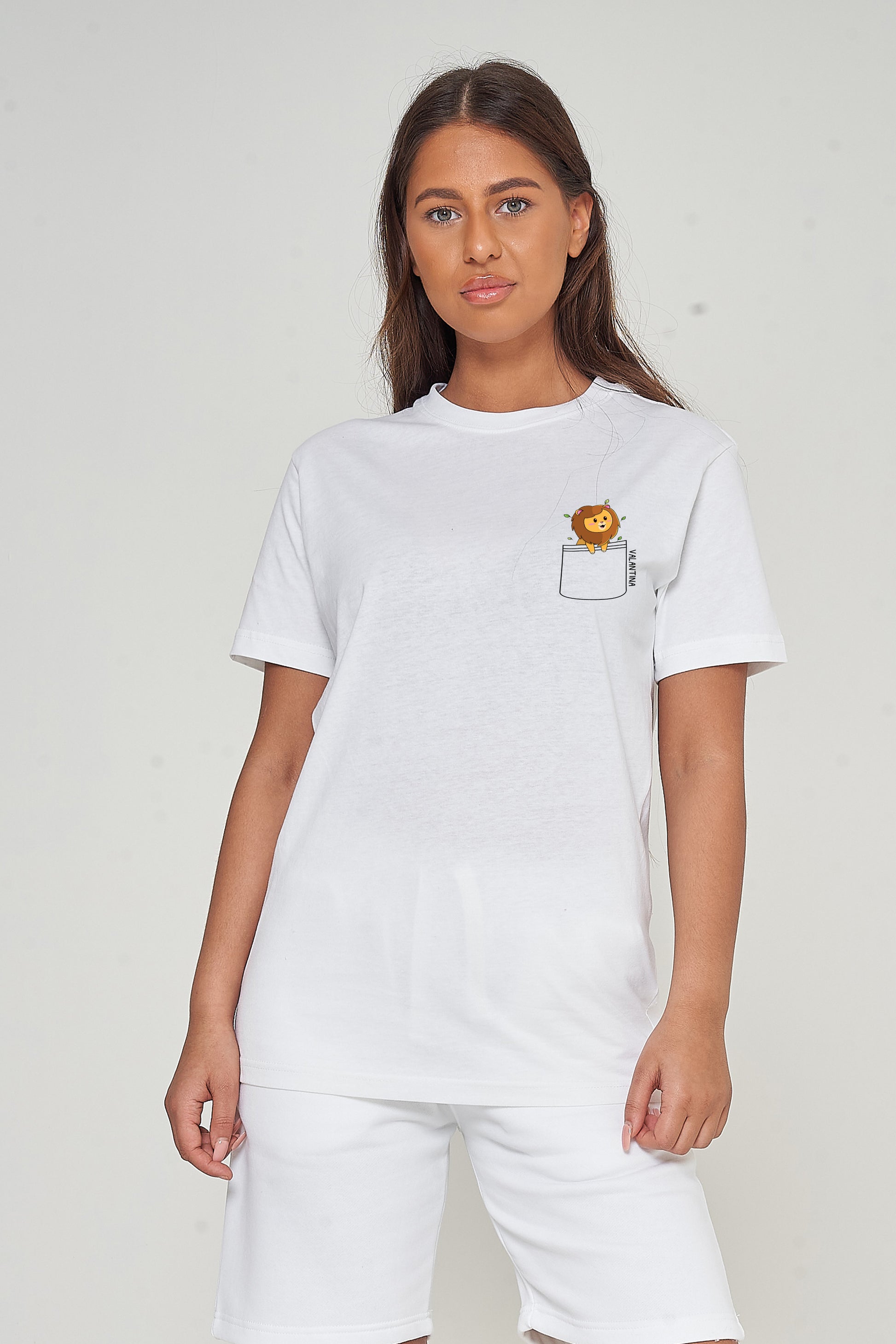 Woman wearing the white Lion Pocket T-Shirt styled with casual bottoms, highlighting the distinctive lion pocket print and comfortable oversized fit. 