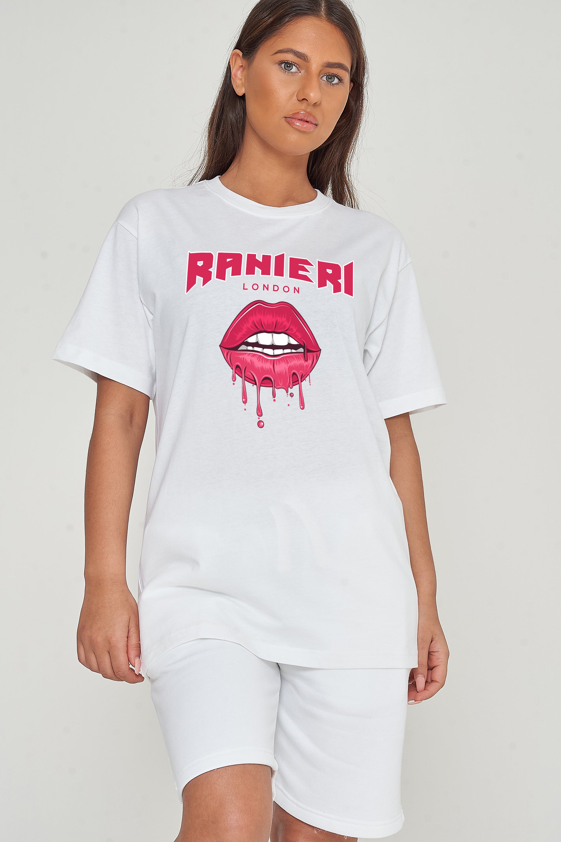 Woman wearing the white Lip Drip Oversized T-Shirt styled with casual bottoms, highlighting the prominent front lip drip graphic and comfortable oversized fit.