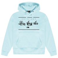 Turquoise blue oversized women’s hoodie featuring a prominent Los Angeles graphic on the chest, adjustable drawstring hood, long sleeves, and ribbed cuffs and hem.