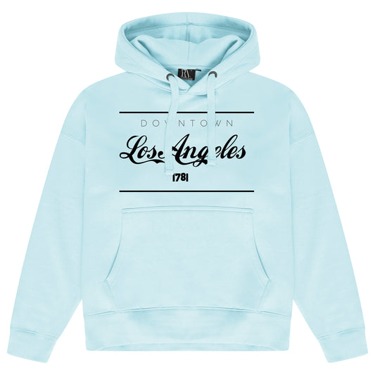 Turquoise blue oversized women’s hoodie featuring a prominent Los Angeles graphic on the chest, adjustable drawstring hood, long sleeves, and ribbed cuffs and hem.