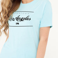 Woman wearing the turquoise Los Angeles Oversized T-Shirt styled with casual bottoms, highlighting the bold front print and comfortable oversized fit.
