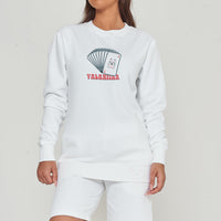 Woman wearing the white Lucky Cards Sweatshirt styled with casual bottoms, highlighting the bold front graphic and comfortable oversized fit.
