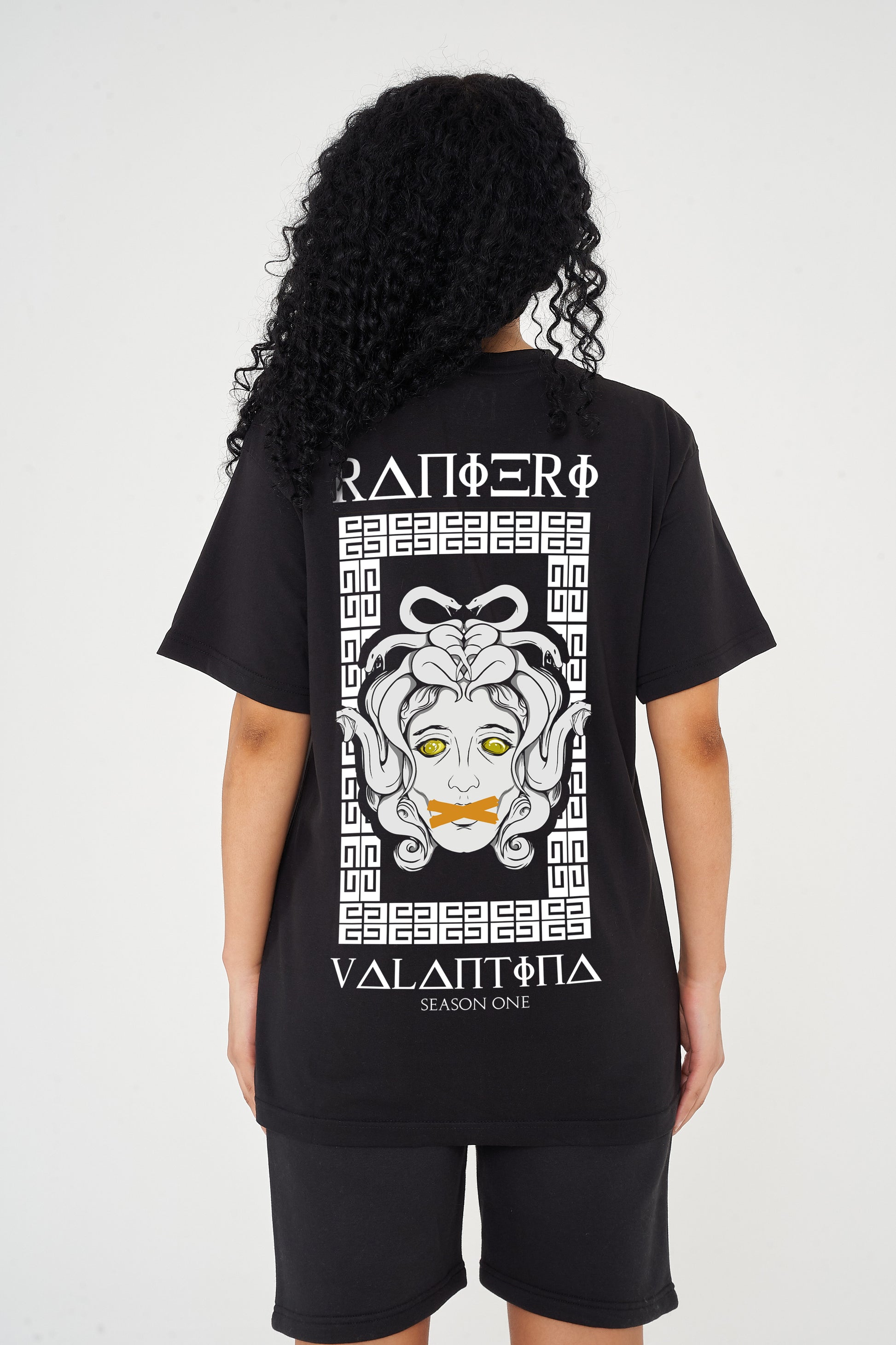 Woman wearing the Medusa Oversized T-Shirt styled with casual bottoms, highlighting the dramatic back graphic and comfortable oversized fit.