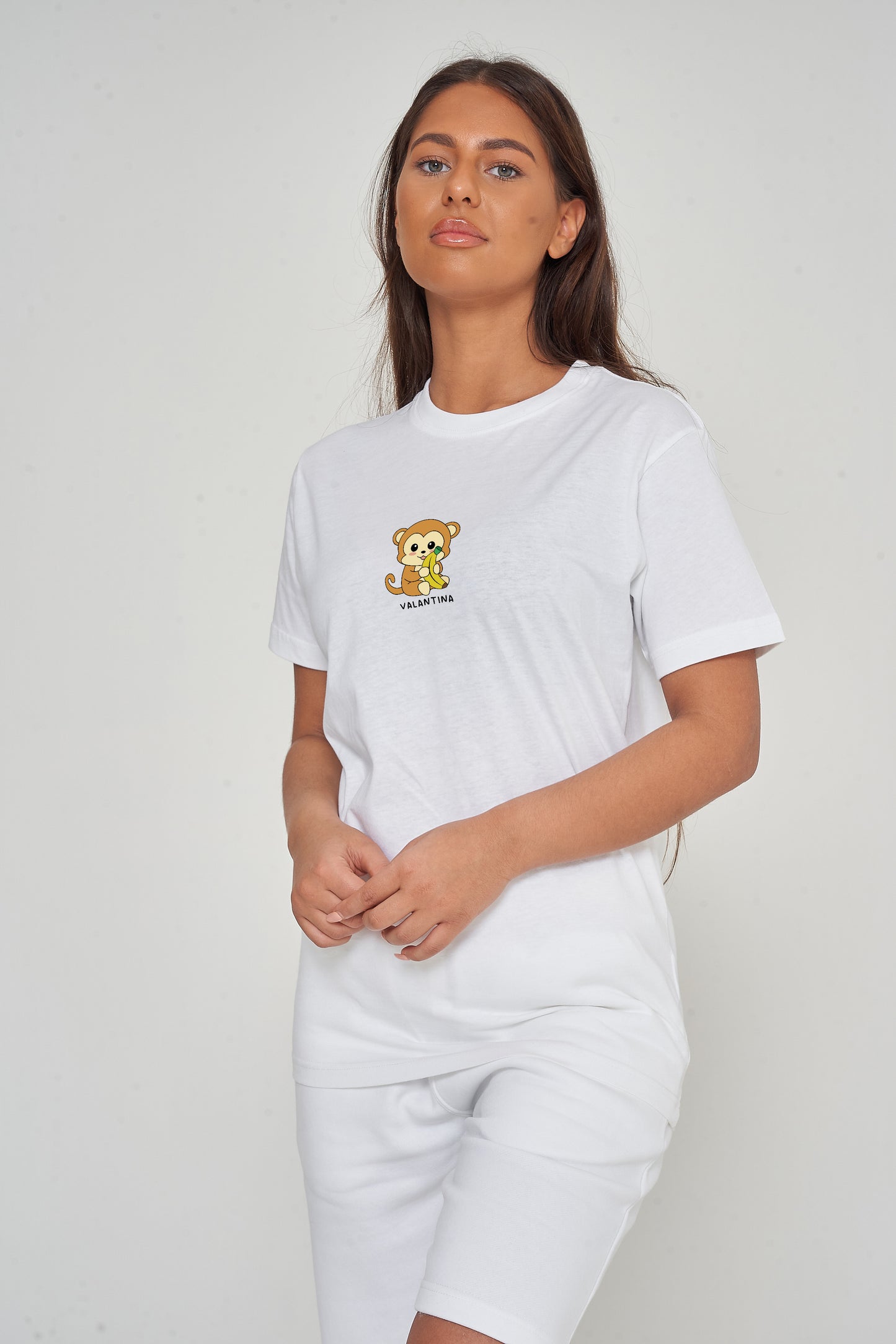 Woman wearing the white Monkey Graphic T-Shirt styled with casual bottoms, highlighting the prominent front monkey print and comfortable oversized fit. 