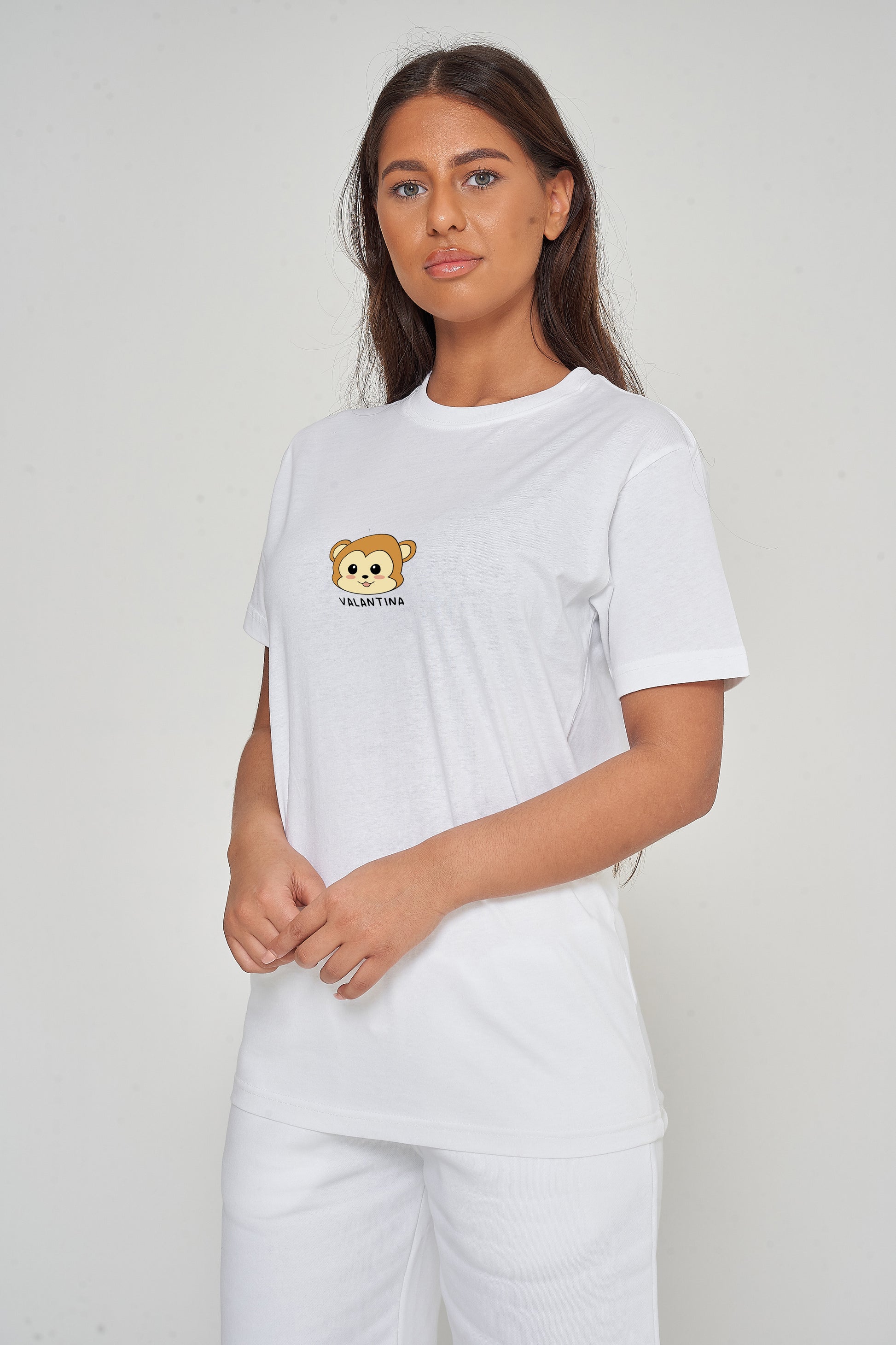 Woman wearing the white Monkey Head T-Shirt styled with casual bottoms, highlighting the prominent front monkey head graphic and comfortable oversized fit. 