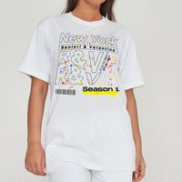 Woman wearing the New York Season 1 Oversized T-Shirt styled with casual bottoms, emphasizing the bold graphic print and comfortable oversized fit.