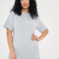 Woman modeling oversized grey t-shirt in a standing side pose, showing relaxed silhouette. 