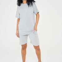 A woman wearing an oversized grey t-shirt with casual shorts, front-facing. 