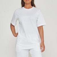 Woman modeling oversized white cotton t-shirt, casual pose with hands by sides.