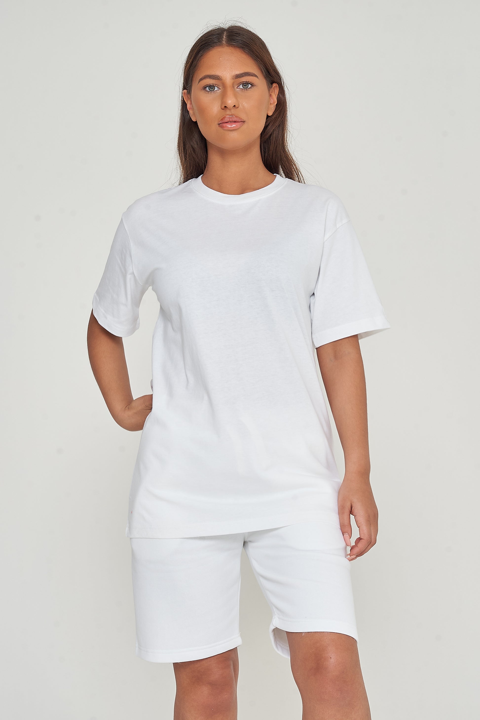 Woman modeling oversized white cotton t-shirt, casual pose with hands by sides.