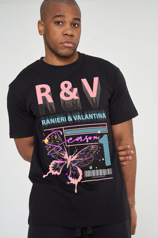 Male model front view wearing black Coral Butterfly Oversized T-shirt with coral butterfly and R&V graphic, styled with casual shorts – oversized fit.