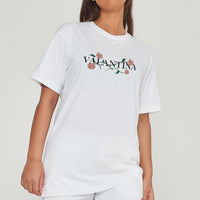 Woman wearing the white Pink Rose Vine Oversized T-Shirt styled with casual denim bottoms, highlighting the front rose vine graphic and comfortable fit.