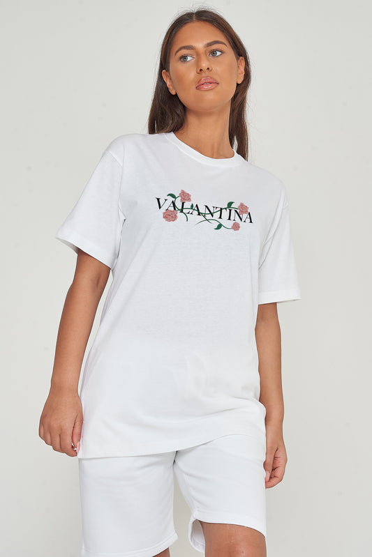 Woman wearing the white Pink Rose Vine Oversized T-Shirt styled with casual denim bottoms, highlighting the front rose vine graphic and comfortable fit.