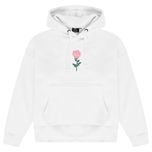 White oversized women’s hoodie featuring a subtle rose graphic printed softly on the chest, adjustable drawstring hood, long sleeves with ribbed cuffs, and ribbed hem.