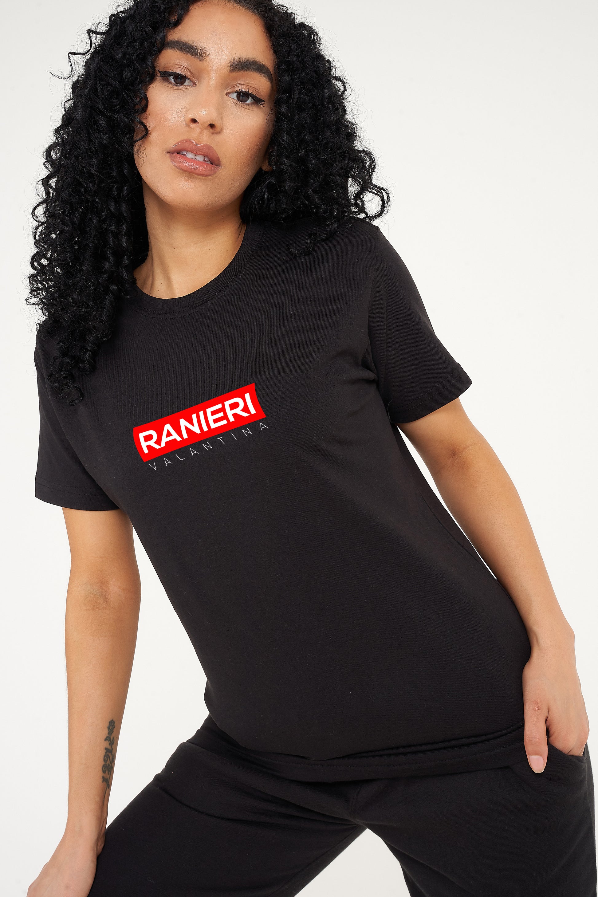 Woman wearing the black Red Box T-Shirt styled with casual bottoms, highlighting the bold front red box graphic and comfortable relaxed fit.
