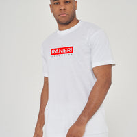 Man wearing the white Red Box T-Shirt styled with casual bottoms, highlighting the bold front red box graphic and comfortable relaxed fit.