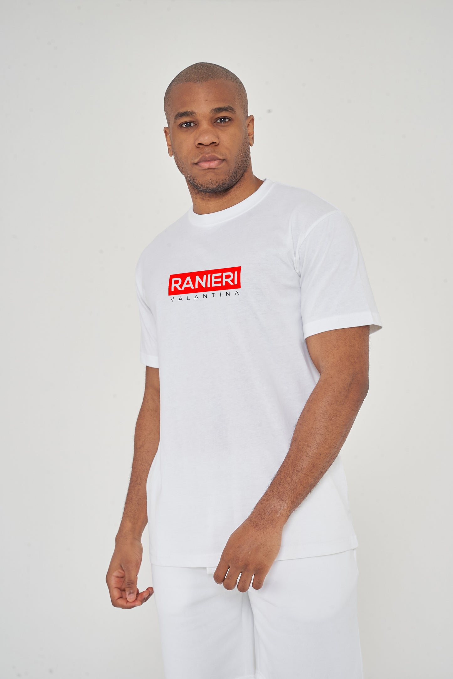 Man wearing the white Red Box T-Shirt styled with casual bottoms, highlighting the bold front red box graphic and comfortable relaxed fit.