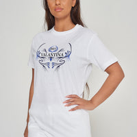 Woman wearing the white Royal Blue Peacock Oversized T-Shirt styled with casual bottoms, highlighting the front graphic and comfortable fit.