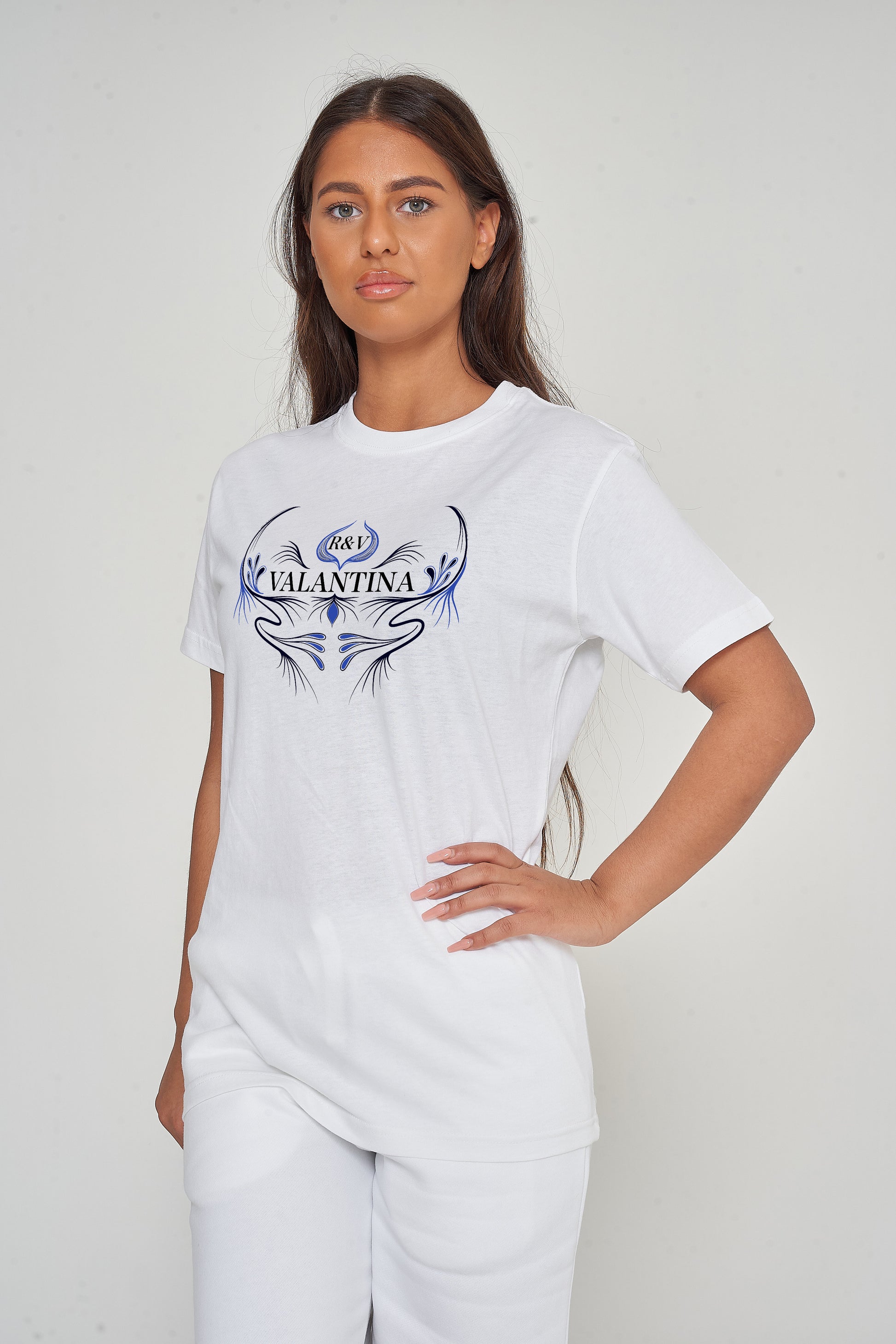 Woman wearing the white Royal Blue Peacock Oversized T-Shirt styled with casual bottoms, highlighting the front graphic and comfortable fit.