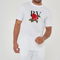 Male model front view wearing white R&V Rose T-shirt with rose graphic, paired with white shorts – regular fit.
