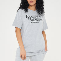 Woman wearing grey oversized Signature Beverly Hills T-shirt and shorts, styled in a modern UK streetwear look.