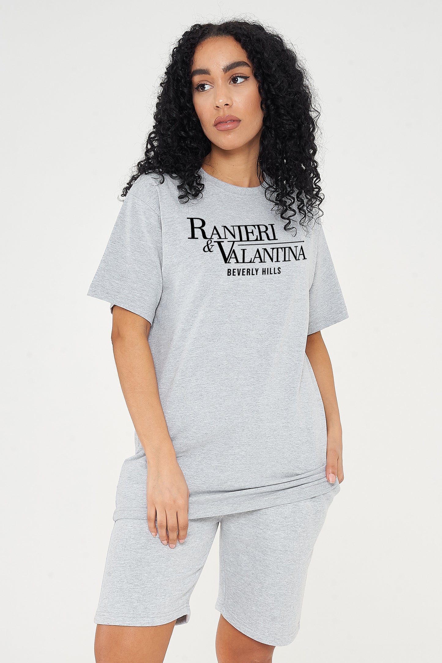 Woman wearing grey oversized Signature Beverly Hills T-shirt and shorts, styled in a modern UK streetwear look.