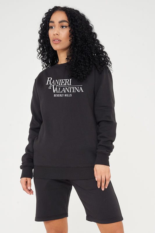 A Woman wearing a black Signature Beverly Hills sweatshirt paired with matching shorts, showcasing UK streetwear style.