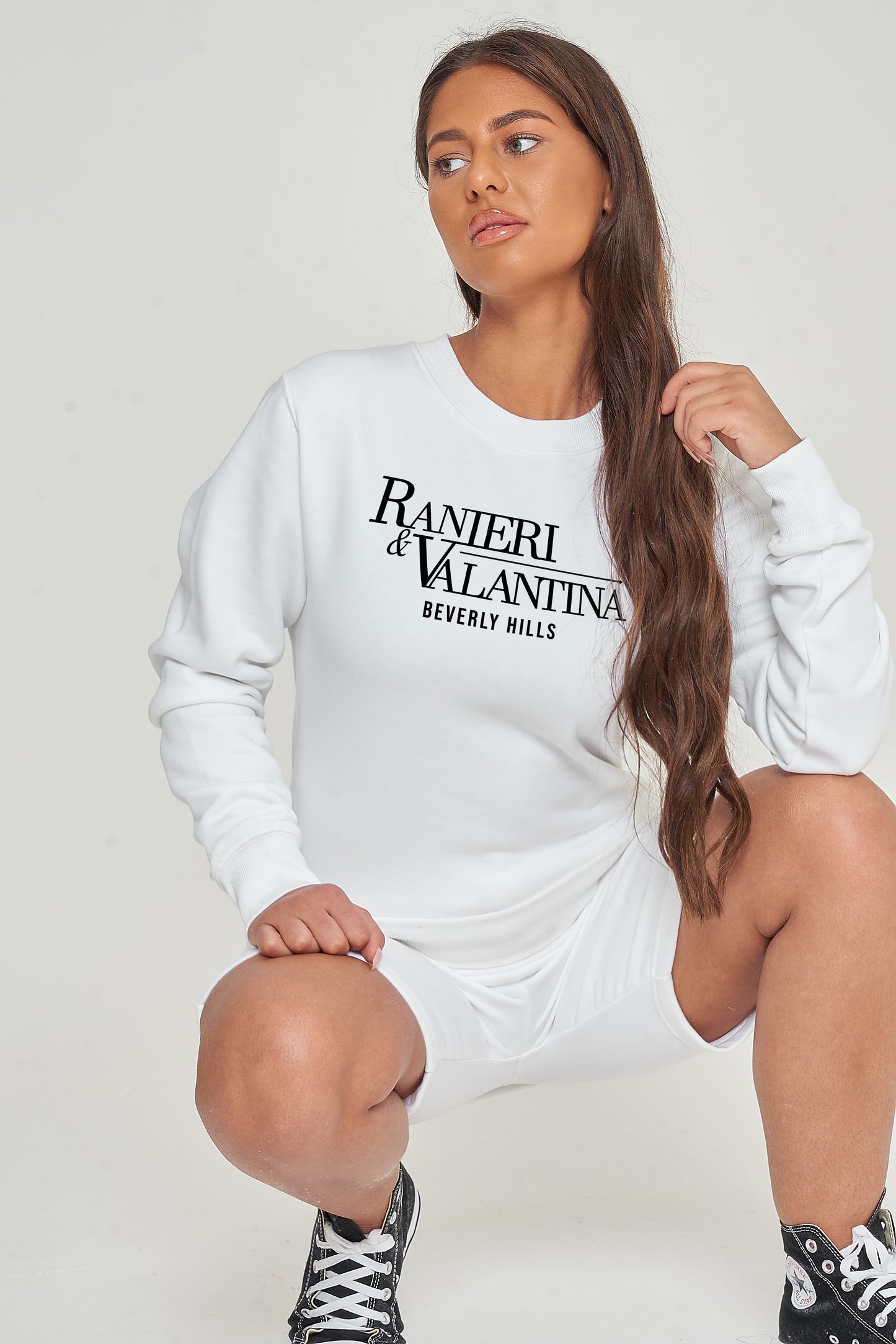 Woman wearing white Signature Beverly Hills sweatshirt paired with shorts, styled for a modern UK streetwear look.