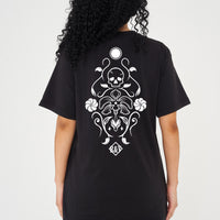 Woman wearing the black Skull Tattoo Oversized T-Shirt styled with casual bottoms, showcasing the striking back graphic and comfortable fit.