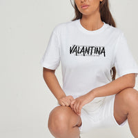 Woman wearing the white Strong Woman Oversized T-Shirt styled with casual bottoms, highlighting the empowering front graphic and comfortable fit.