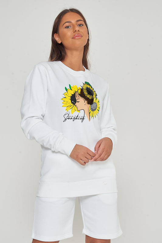 Woman wearing the white Sunflower Girl Sweatshirt styled with casual bottoms, highlighting the front sunflower print and cosy silhouette.