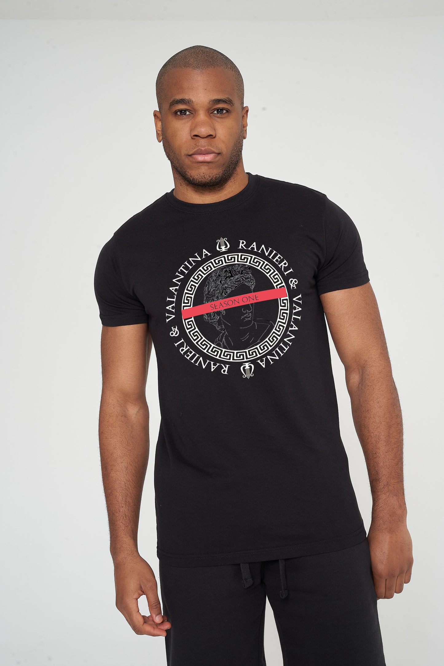 Male model front view wearing black Unseen Oversized T-shirt with circular front graphic, styled with casual shorts – oversized fit.